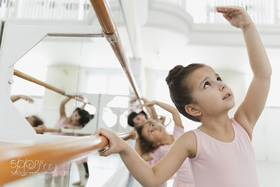 Photograph Children practicing ballet poses in ballet studio by Hero Images  on 500px